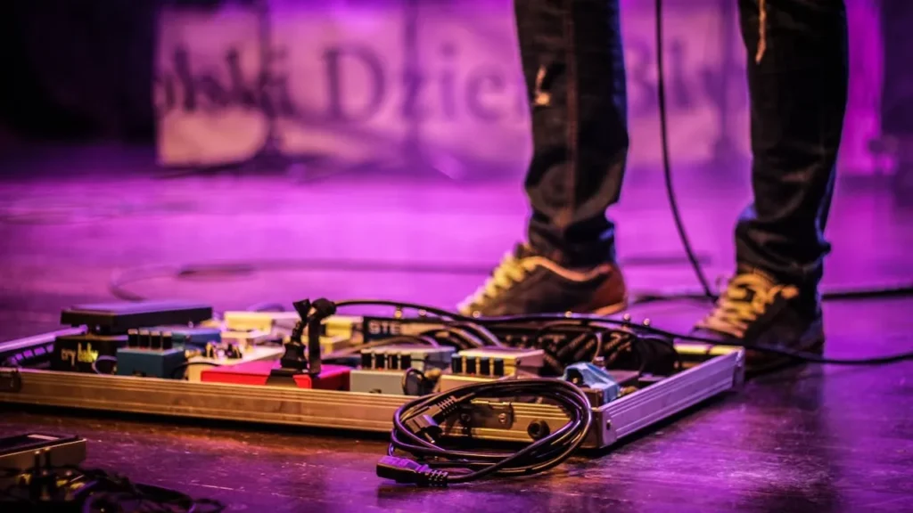 Guitar pedalboard next to guitarist feet