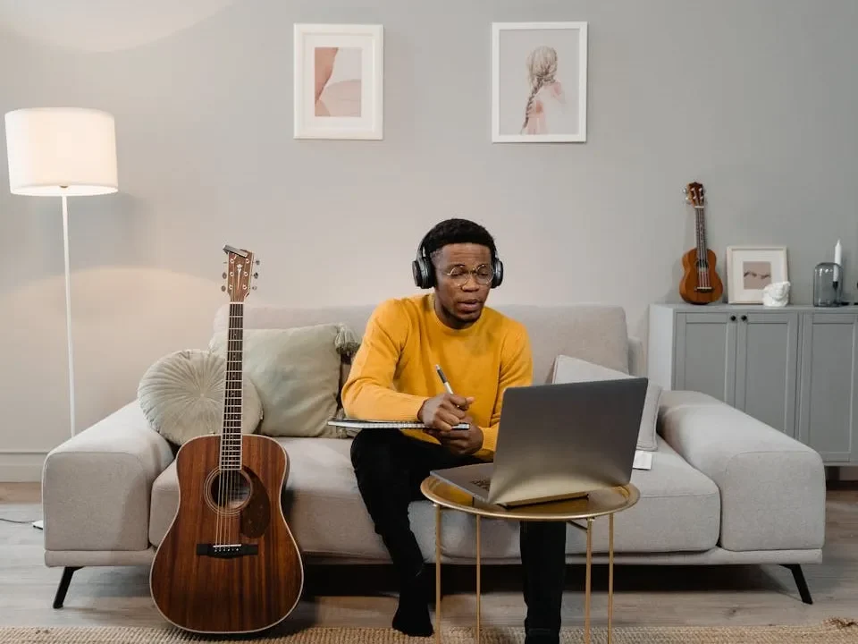 Musicians sitting on the sofa and planning using laptop