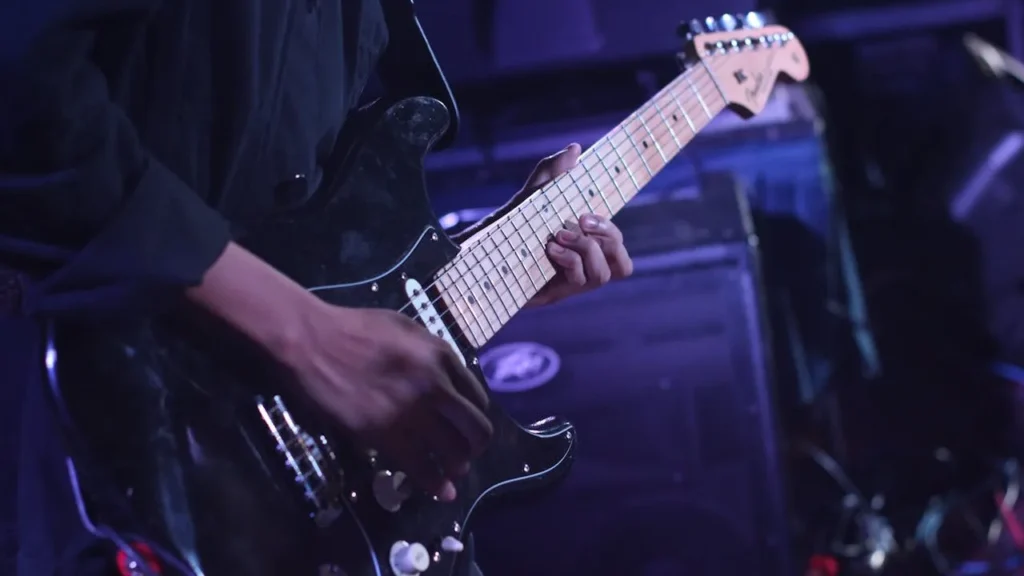 Image of a guitarist playing the guitar on stage