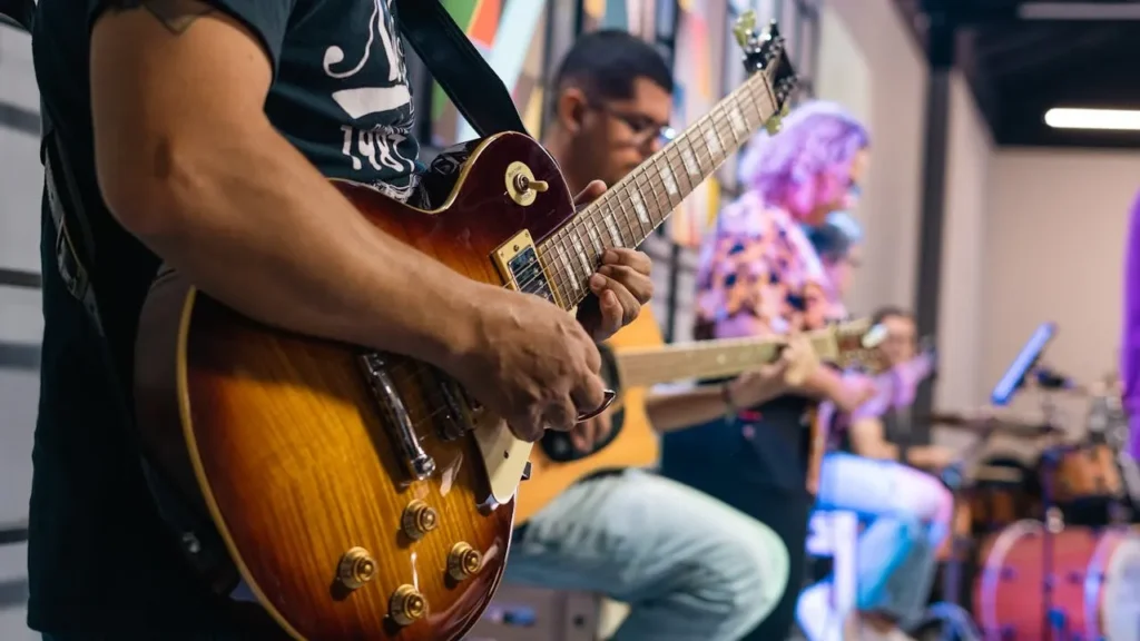 Image of a guitarist playing a band and performing on stage