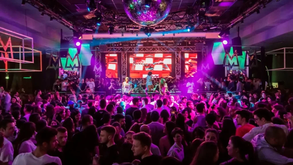 Image of stage in a club with a band and crowd